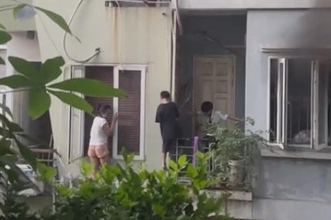 Các thành viên trong gia đình anh Q. leo ban công thoát sang ngôi nhà bên cạnh (Ảnh: Tổ quốc).