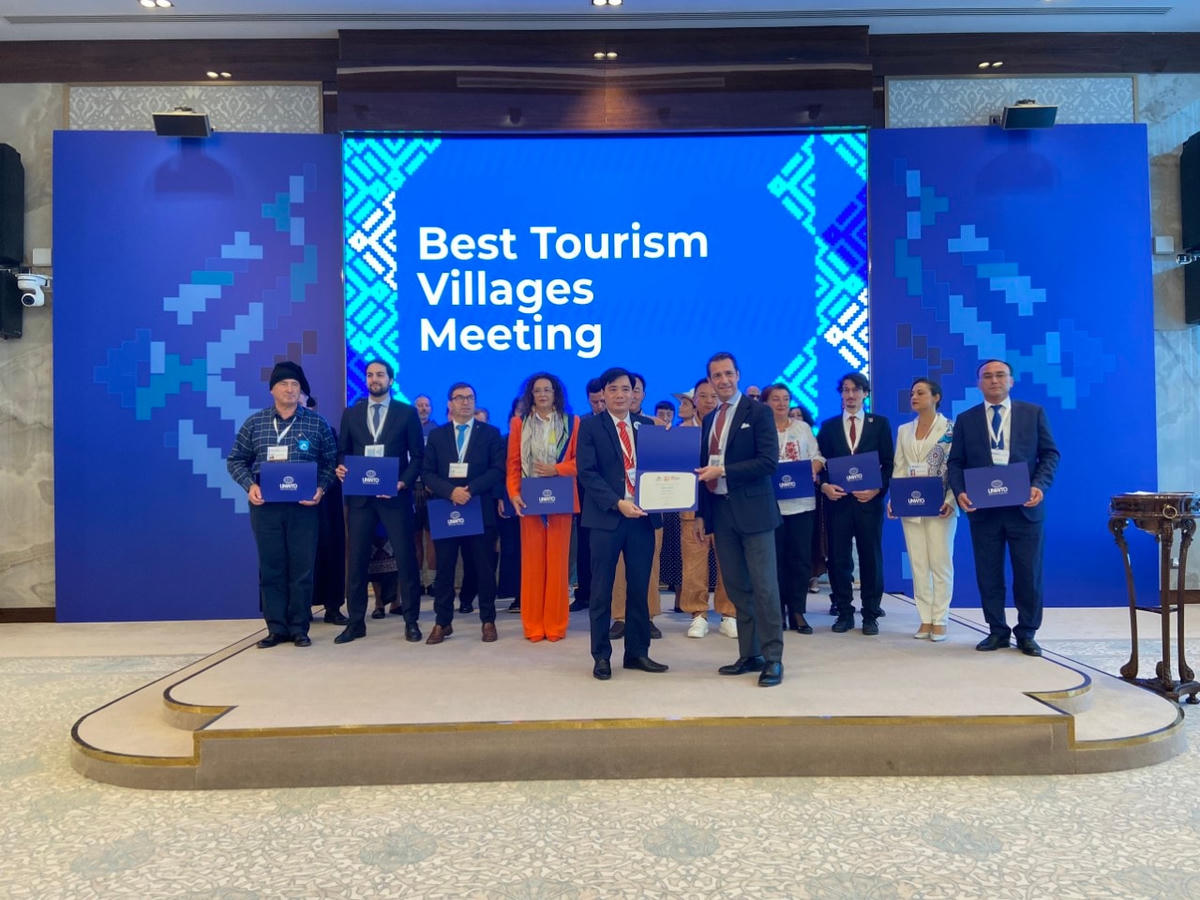 Đại diện lãnh đạo UBND xã Tân Hóa nhận giải thưởng của Tổ chức Du lịch thế giới.