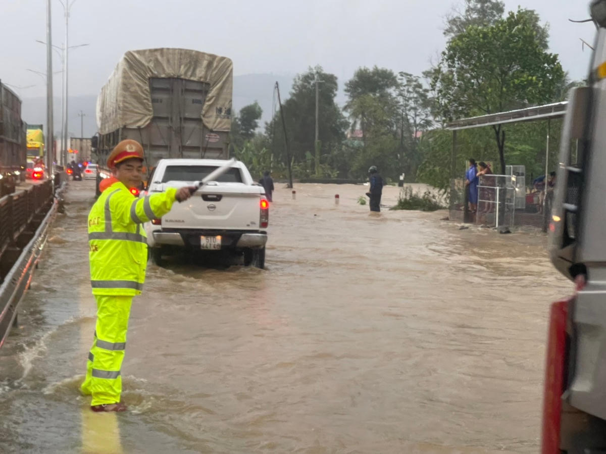 Lực lượng chức năng tổ chức phân luồng, hướng dẫn phương tiện khi lưu thông qua tuyến đường bị ngập.