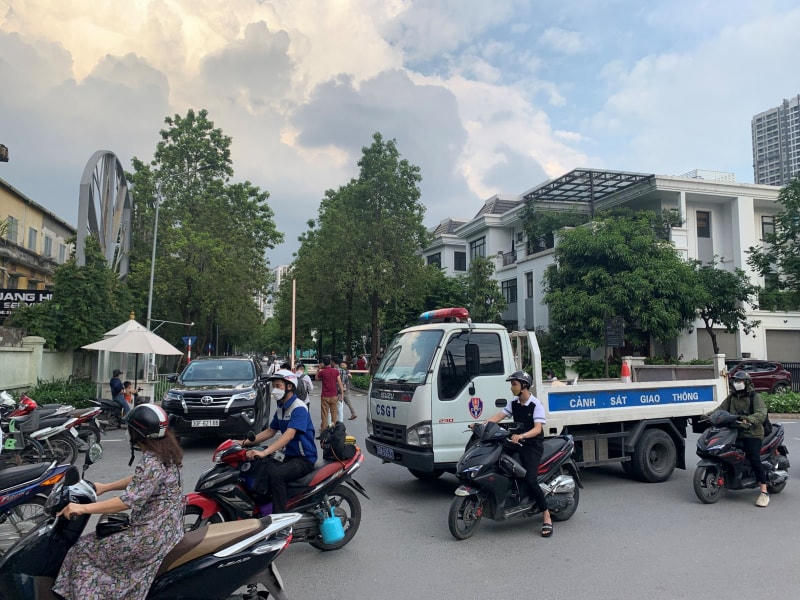 Lực lượng CSGT đưa xe ra để đảm bảo ATGT trong lối vào khu vực nhà ông Chu Ngọc Anh. Ảnh: CAND.
