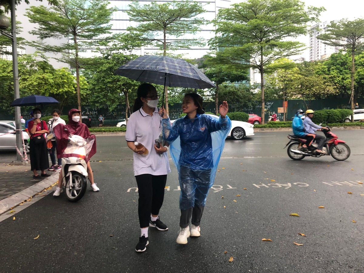 Đến cổng, các bạn được tình nguyện viên che mưa dẫn vào kèm lời chúc làm bài tốt.