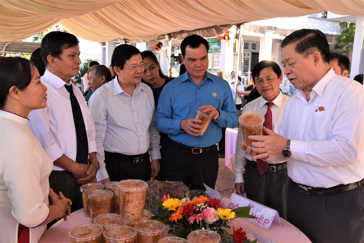 Trưởng ban Tuyên giáo Trung ương Nguyễn Trọng Nghĩa cùng các lãnh đạo dự Ngày hội tham quan các sản phẩm do người dân địa phương làm. Ảnh: N.D..