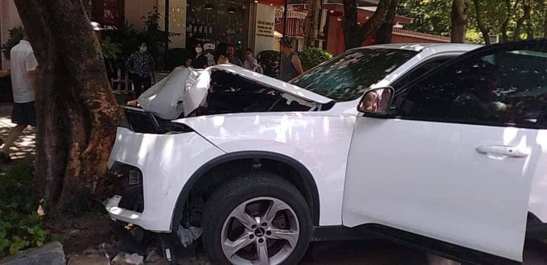 Sau khi va chạm với xe máy, chiếc xe ô tô tiếp tục lao lên vỉa hè và chỉ dừng lại khi đâm vào gốc cây bên đường.