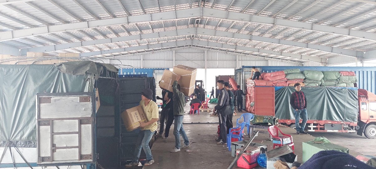 Bốc xếp hàng hóa nhập khẩu tại bãi kiểm hóa Lối mở cầu phao tạm Km3+4 Hải Yên, Móng Cái.