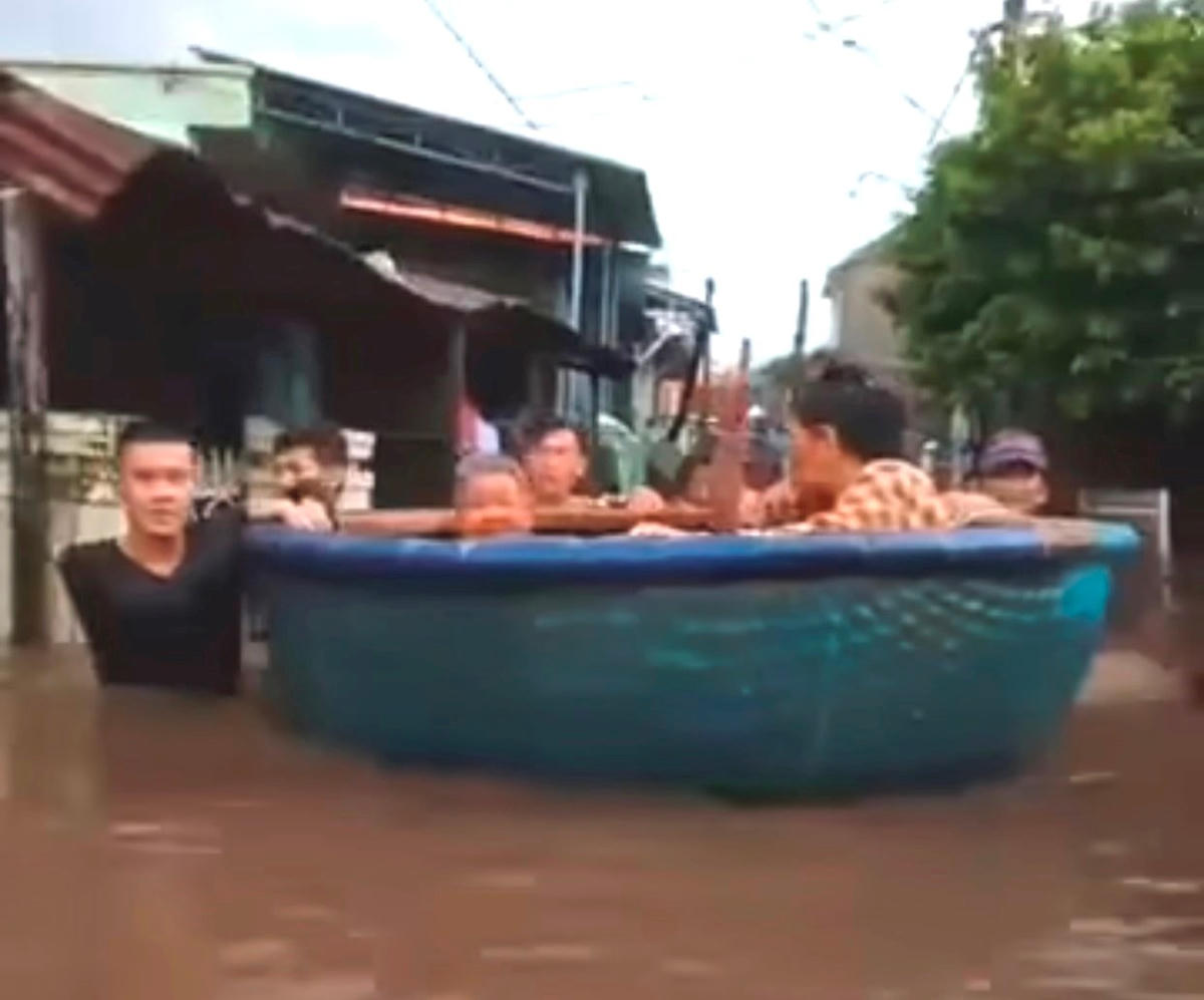 Người dân dùng thuyền thúng để đưa người già đến nơi tránh trú.