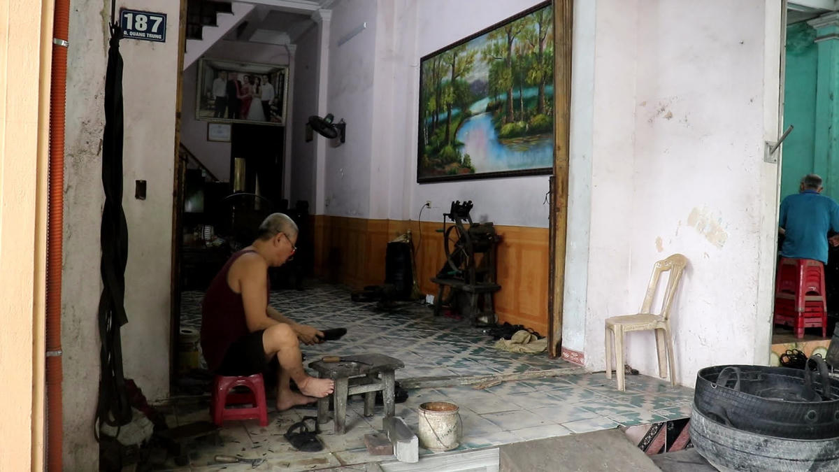 Bước vào ngôi nhà số 187 đường Quang Trung, chúng tôi bắt gặp ông Lê Văn Dung đang cặm cụi, tỉ mỉ cắt gọt tạo từng chi tiết cho chiếc đế dép cao su bên chiếc quạt máy cũ.