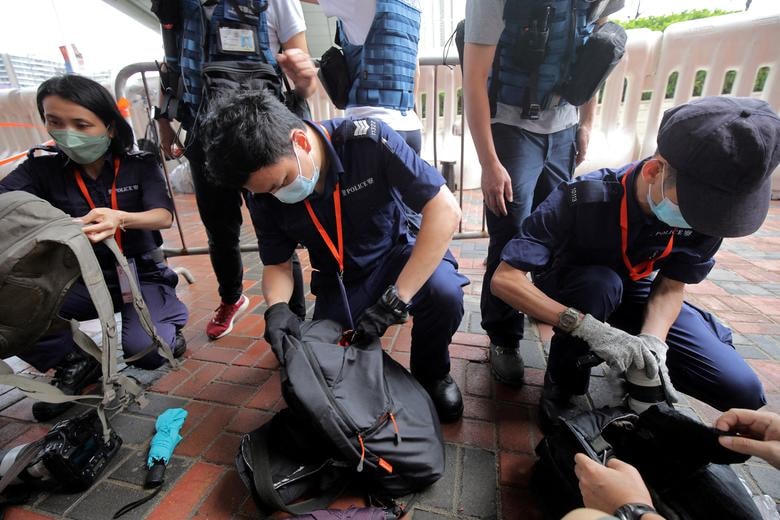 Cảnh sát kiểm tra tư trang của các phóng viên tác nghiệp ngoài nhà ga West Kowloon. Ảnh: Reuters.