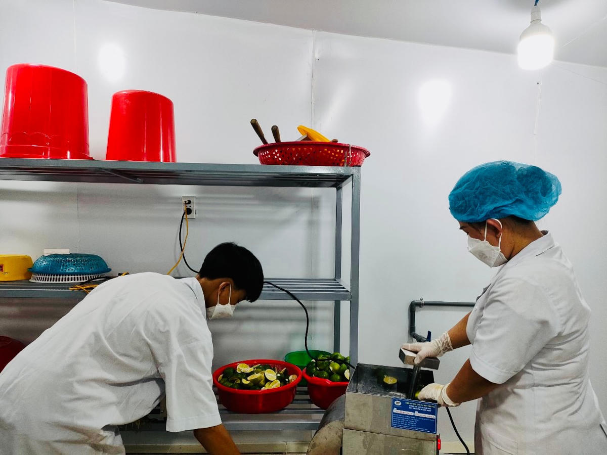 Chị Nguyễn Thị Hồng Vân cùng con trai đang ép nước cốt chanh.