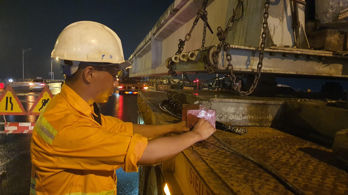 Các công nhân đang kiểm tra các thiết bị trên xe đảm bao an toàn trong khi vận chuyển.