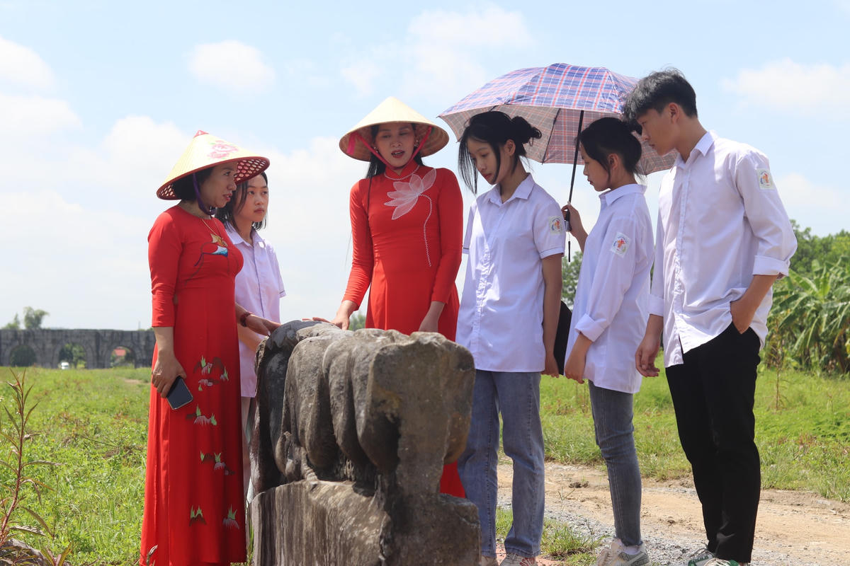 Vào sâu bên trong Nội thành, các bạn học sinh được hướng dẫn viên kể câu chuyện về đôi rồng đá được phát hiện năm 1938.  Ảnh: Đình Minh 