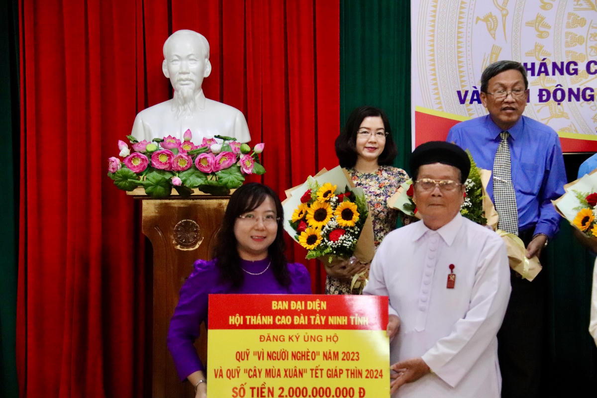Phó Chủ tịch Uỷ ban MTTQ Việt Nam tỉnh An Giang Nguyễn Thị Tuyết Minh nhận bảng biểu trưng đăng ký ủng hộ quỹ.
