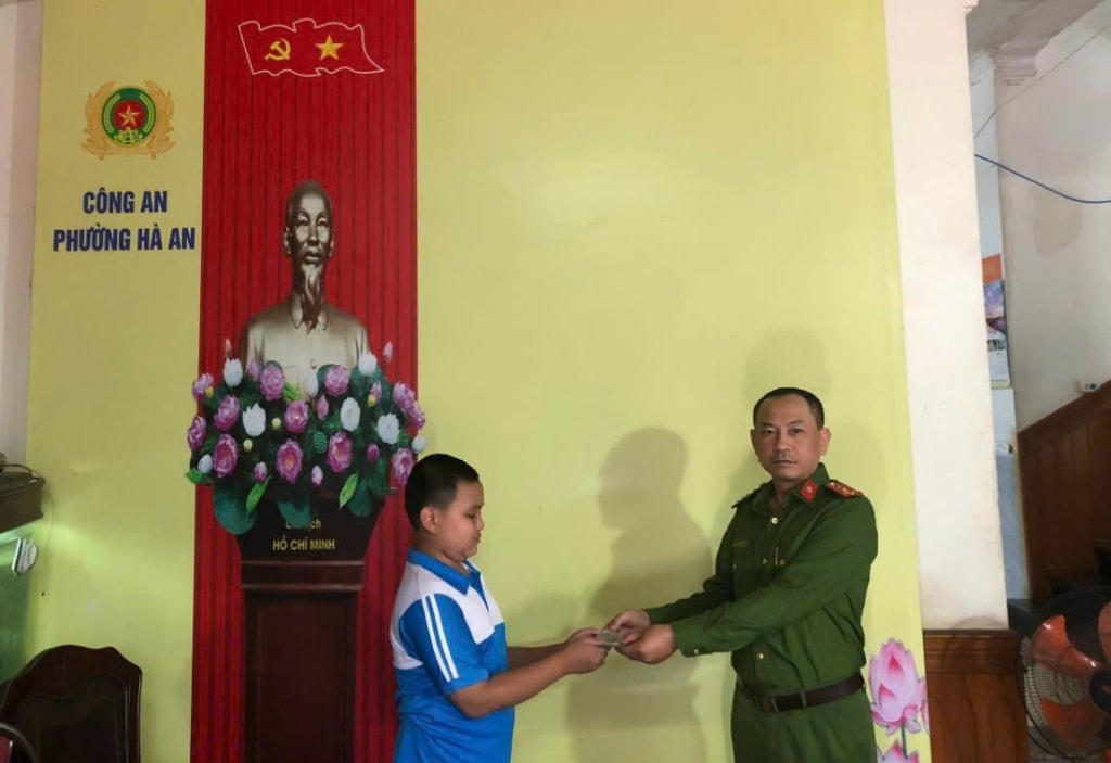 Em Phạm Tiến Thành (lớp 6A, Trường THCS Hà An) bàn giao số tiền 28,5 triệu đồng nhặt được cho Công an phường Hà An để trả lại người đánh rơi. (Nguồn: Báo Quảng Ninh)