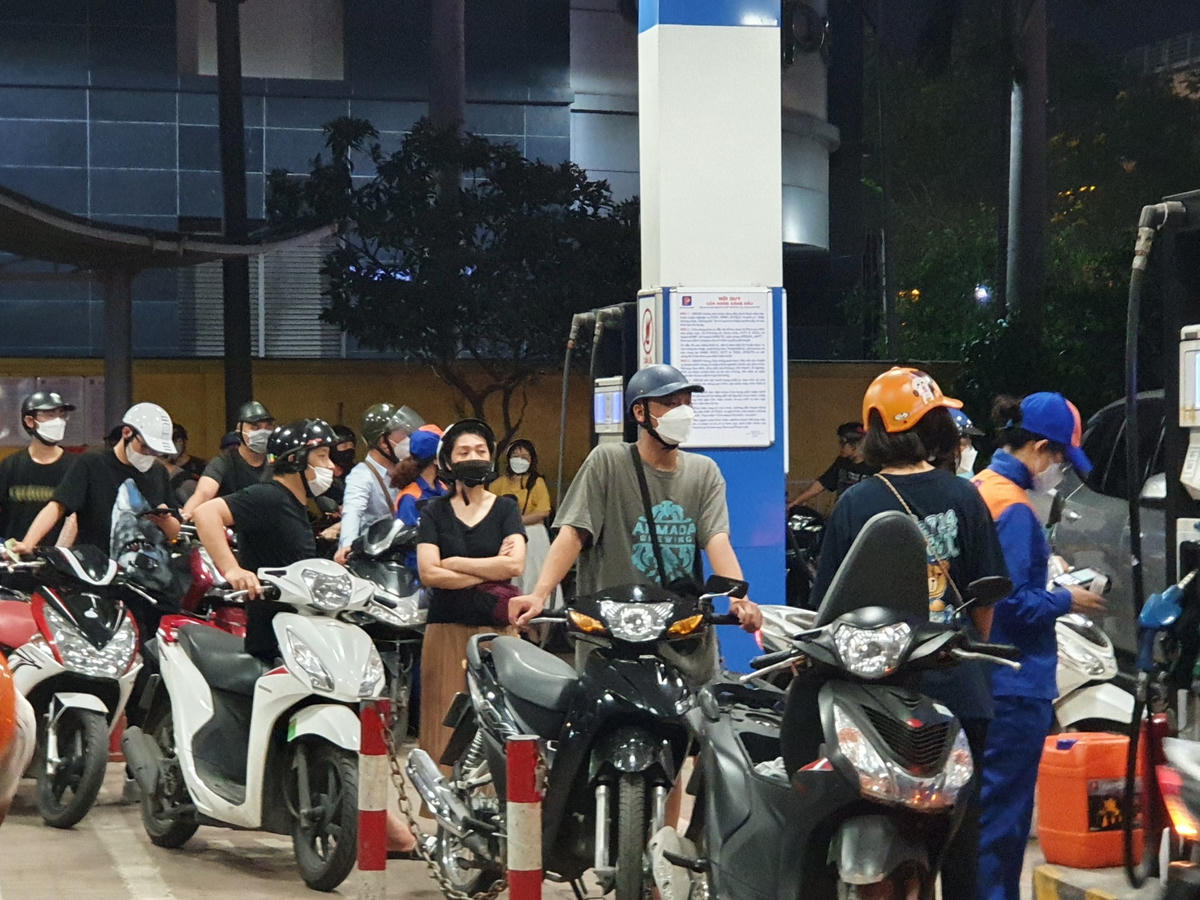 Nhân viên tại cây xăng tất bật hoạt động vì lượng phương tiện đổ xô mua xăng...