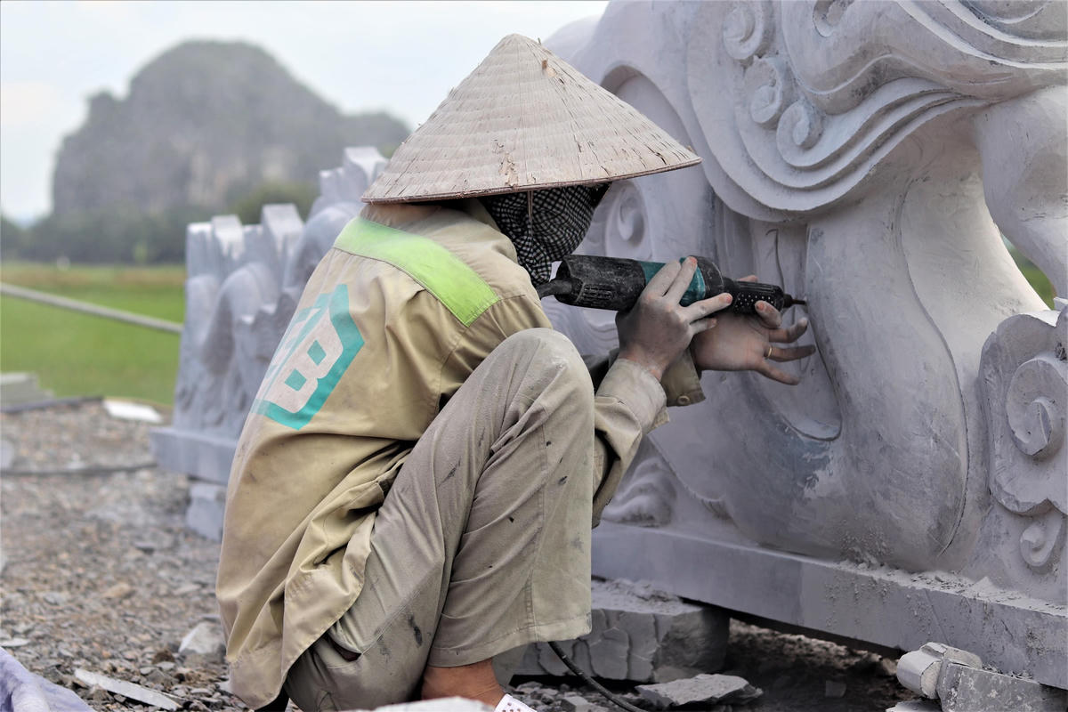 Một nghệ nhân đang tạo tác rồng đá với những đường nét tinh xảo