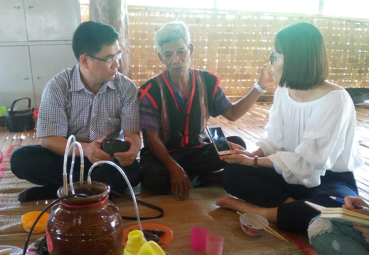 Nhà báo Trần Hồng Quỳnh (ngoài cùng bên trái) trao đổi với già làng A Biêng dân tộc Xơ Đăng tại thôn Kon Lung, xã Đăk Tờ Lung, huyện Kon Rẫy, tỉnh Kon Tum.  