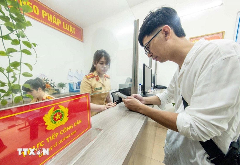 Cán bộ, chiến sỹ Công an phường Cửa Nam, thành phố Hà Nội tiếp nhận và hướng dẫn người dân đến làm thủ tục đăng ký xe môtô. (Ảnh: Phạm Kiên/TTXVN)