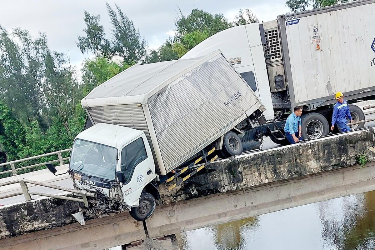 Phần đầu chiếc xe tải nằm gọn trên thành cầu, suýt rơi xuống sông.