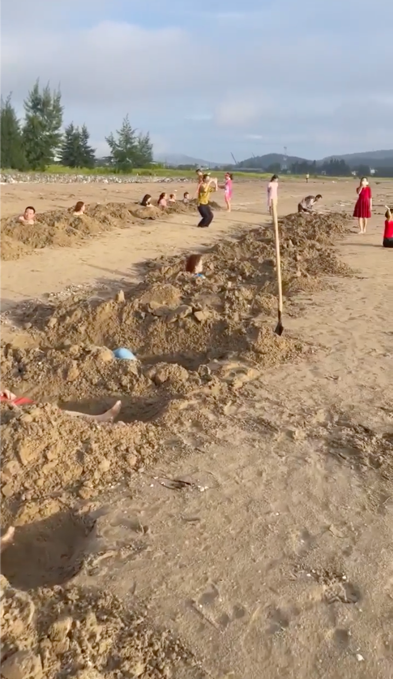 Hàng chục hố cát được du khách đào xới, sau đó "ngâm" mình để tắm cát.