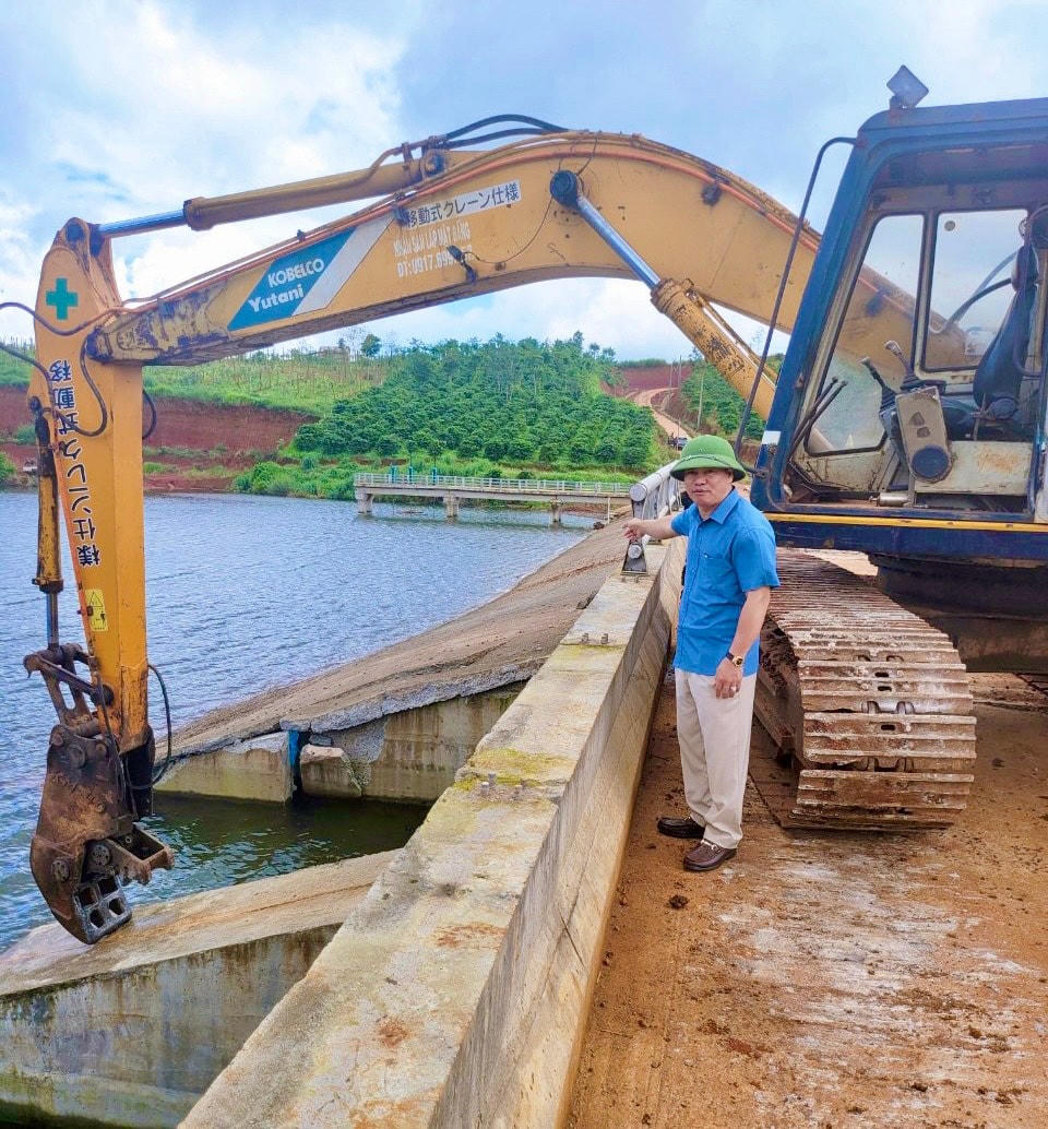 Ông Nguyễn Văn Nghĩa đang cho máy cắt tràn xả lũ cứu “bom nước” 2,1 triệu m3.
