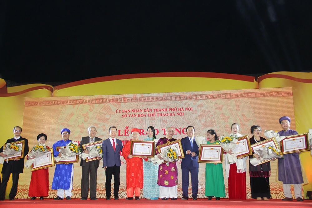 Phó Chủ tịch UBND TP Hà Nội Chử Xuân Dũng và PGS, TS Bùi Hoài Sơn, Ủy viên thường trực Ủy ban Văn hóa, Giáo dục của Quốc hội trao tặng danh hiệu Nghệ nhân Nhân dân.
