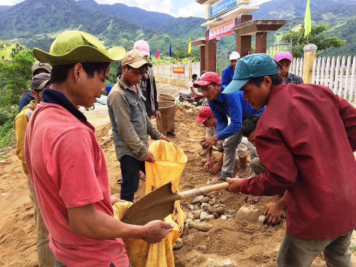 Thanh niên đồng bào Xê Đăng thôn Long Túc, xã Trà Nam cùng làm đường bê tông.
