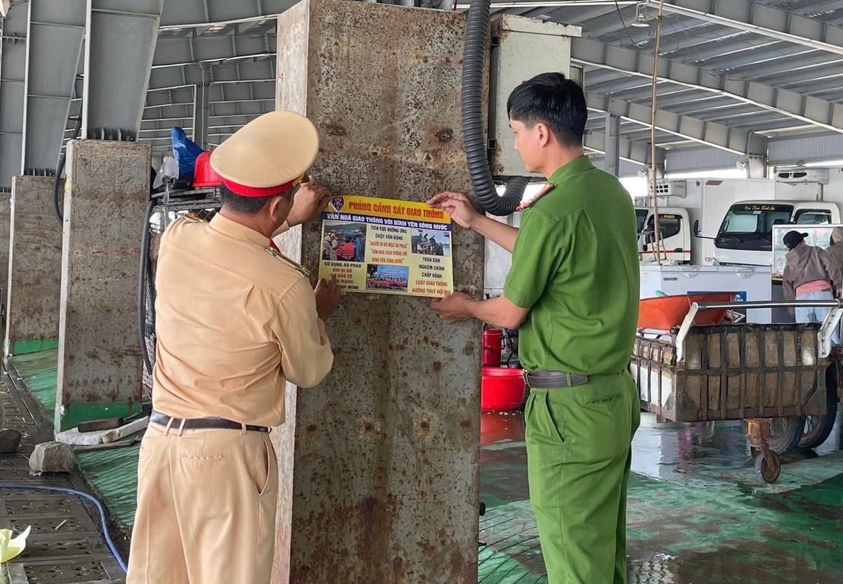 Lực lượng chức năng dán tờ rơi tuyên truyền luật giao thông đường thuỷ đến người dân (1)