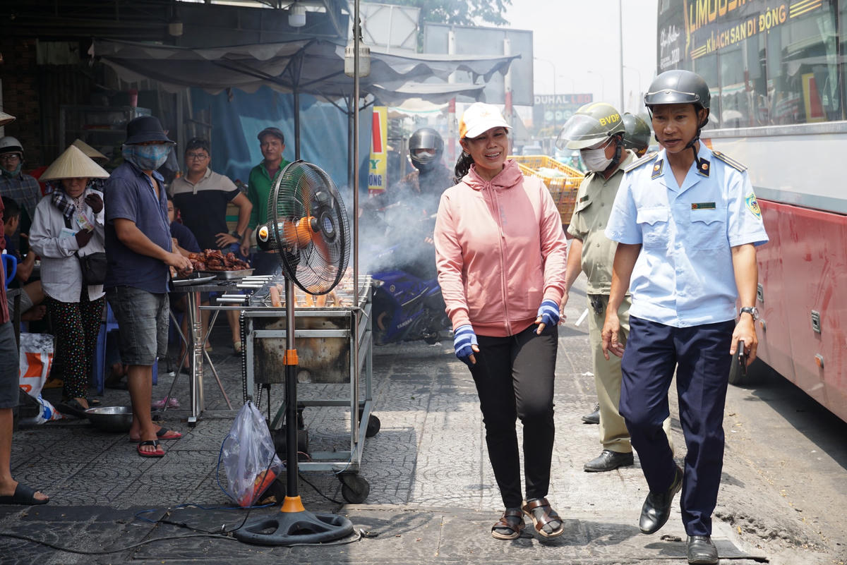 Một người bán cơm chạy theo phân trần với lực lượng chức năng phường khi thấy tình hình "căng". Ảnh: Mạnh Thìn.