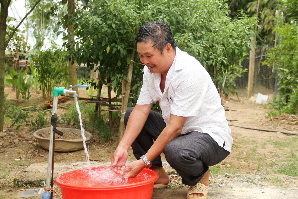 Ông Ngô Đức Vỹ phấn khởi khi gia đình đã có nguồn nước sạch. 