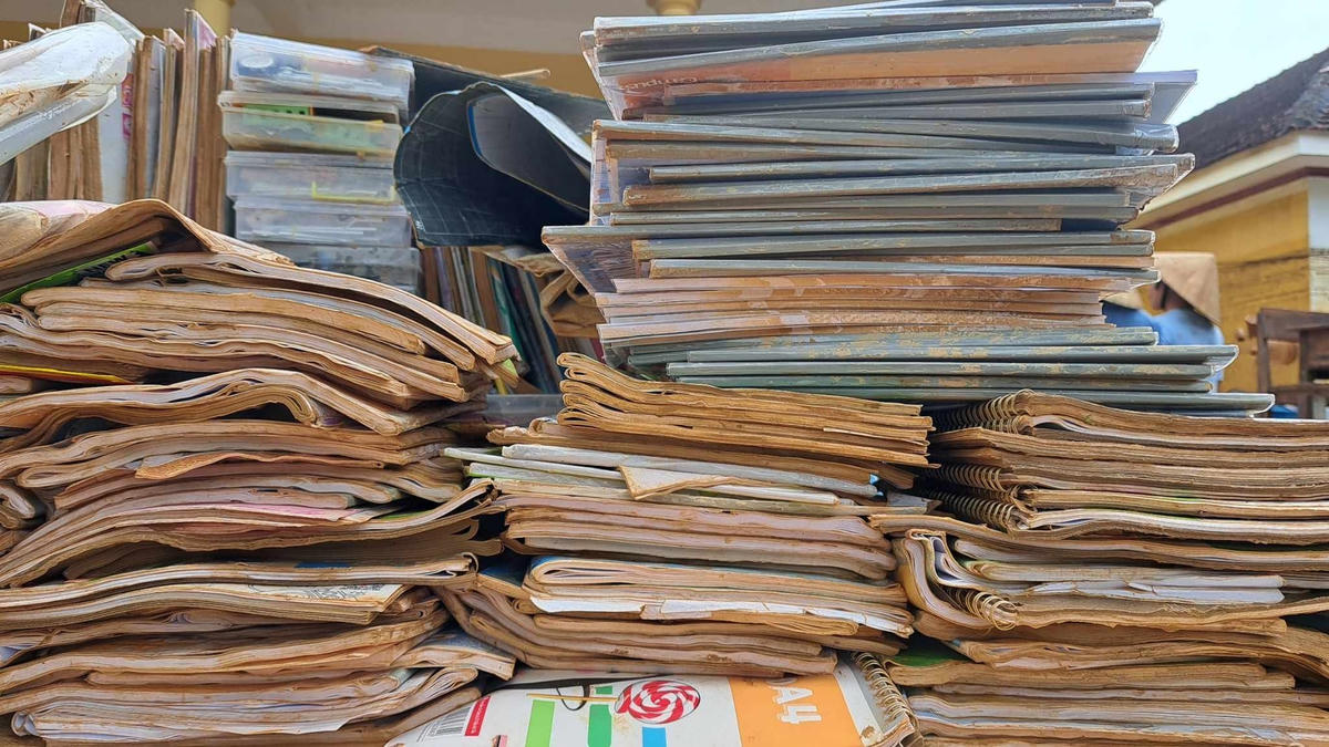 Sách vở học sinh bị chìm trong nước lũ, được chất thành đống, chờ trời nắng để hong khô.