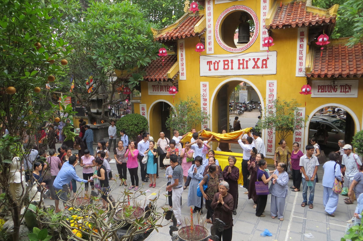 Người dân đến lễ chùa Quán Sứ (Hà Nội), phía sau là cổng chùa  với 4 chữ "Từ, Bi, Hỉ, Xả".  