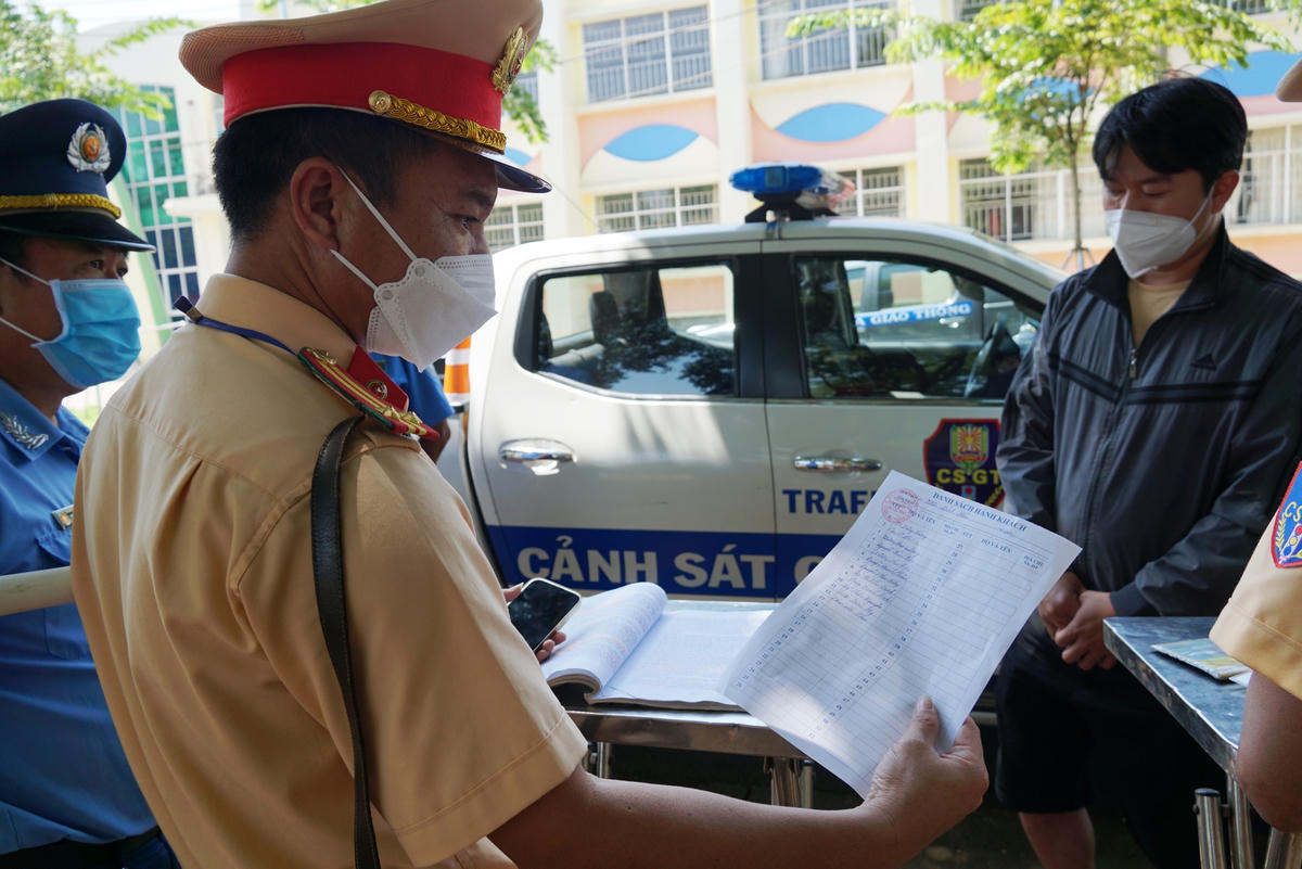 Đội CSGT-TT Công an TP Long Khánh kiểm tra danh sách học sinh của một phương tiện đưa đón. Ảnh: Mạnh Thìn.