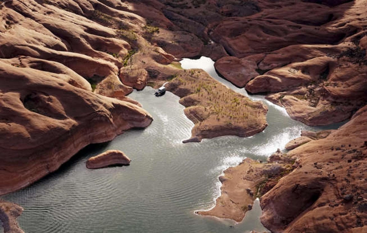 Một con thuyền ở sát mép bờ của vùng nước nông trong một hẻm núi ở Hồ Powell gần Page, Arizona. Hồ nước này nằm trên dòng sông Colorado đã cung cấp nước cho các bang Nevada, Arizona và California.  
