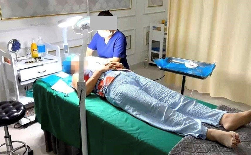Nhân viên lao công cơ sở thẩm mỹ Kangzin ở số 368 đường Hùng Vương đang phẫu thuật, căng da mặt cho một phụ nữ. Ảnh: Công an Đà Nẵng.
