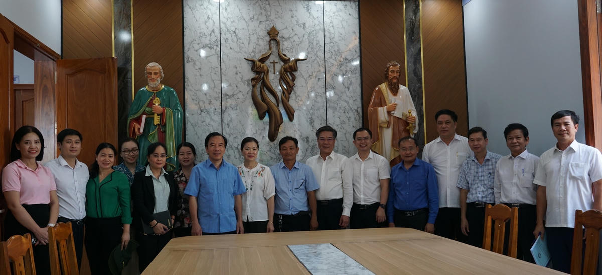 Đoàn công tác chụp hình lưu niệm tại Nhà thờ Giáo xứ Thành Đức trong khu tái định cư. Ảnh: Mạnh Thìn.