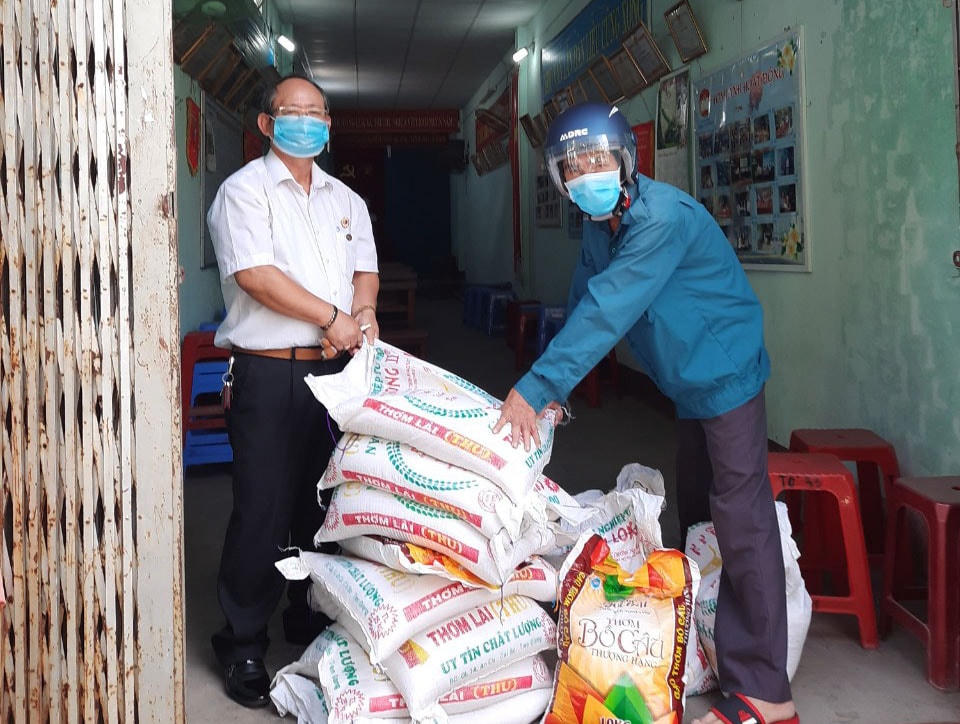 Ông Nguyễn Đức Cử (trái) hỗ trợ gạo cho người nghèo gặp nhiều khó khăn do Covid-19 năm 2022.