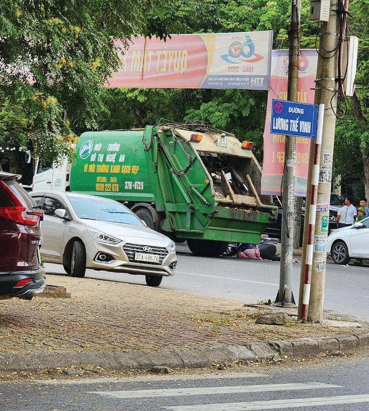 Trước khi bị xe chở rác cán qua người, người phụ nữ đã va chạm với cánh cửa của 1 xe ô tô con đậu bên đường khi người này bất ngờ mở cửa.
