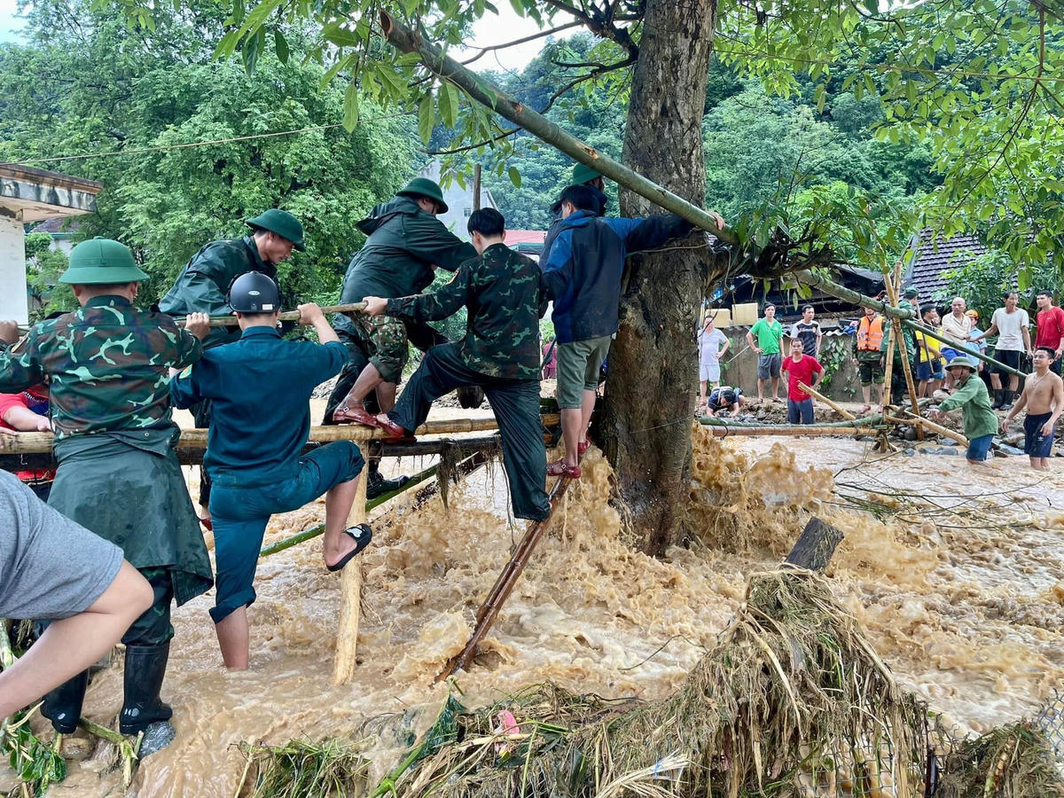 Lực lượng chức năng "vượt cầu" vào với người dân trong các bản đang bị cô lập.