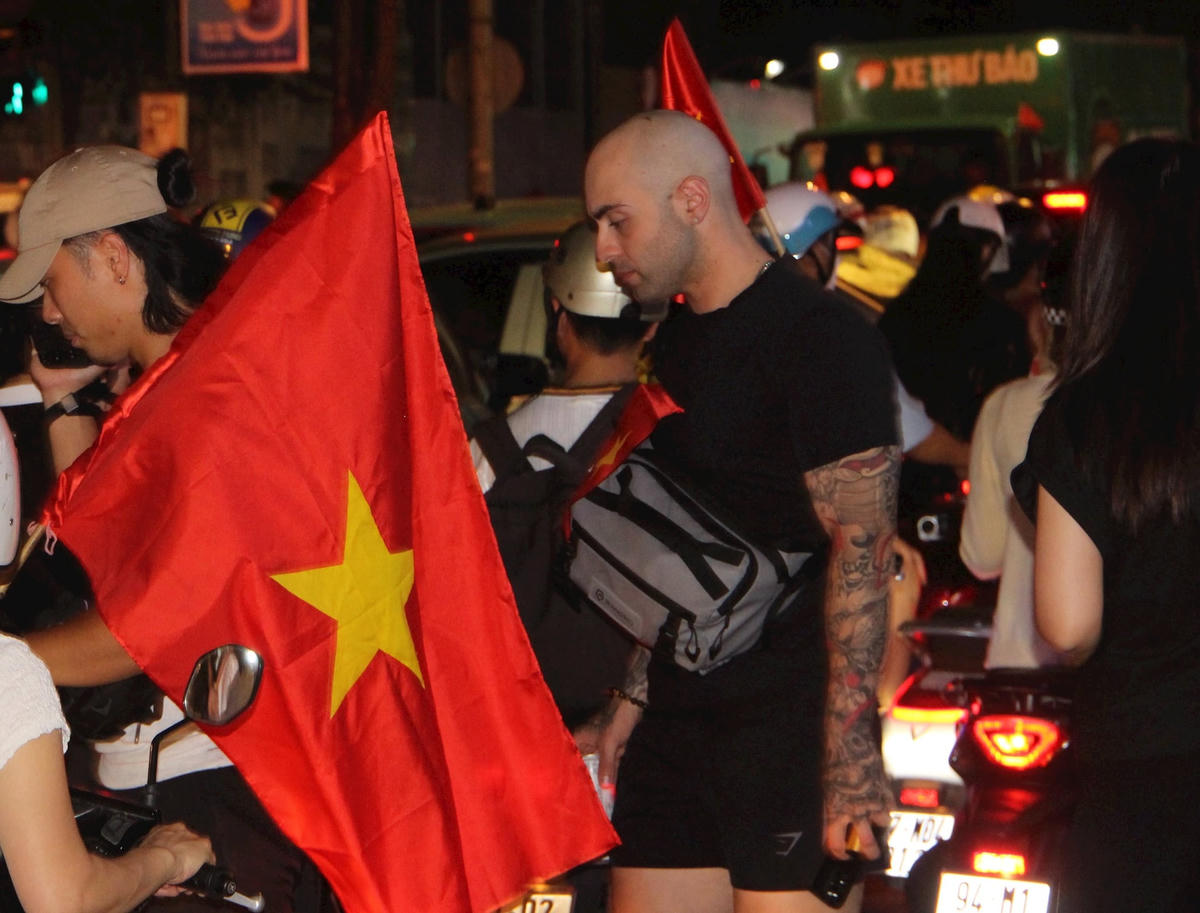 Nhiều người nước ngoài cùng hoà vào dòng người, chung vui niềm lễ kỷ niệm.