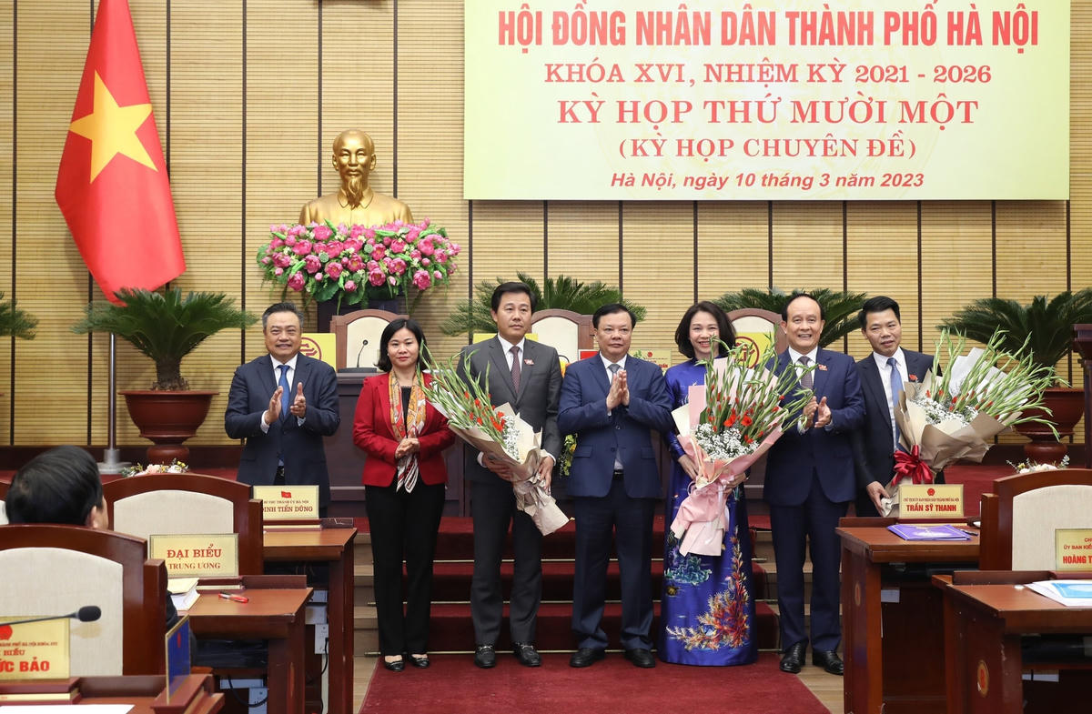 Bí thư Thành ủy Hà Nội Đinh Tiến Dũng tặng hoa và chúc mừng các cá nhân vừa được HĐND TP Hà Nội bầu.