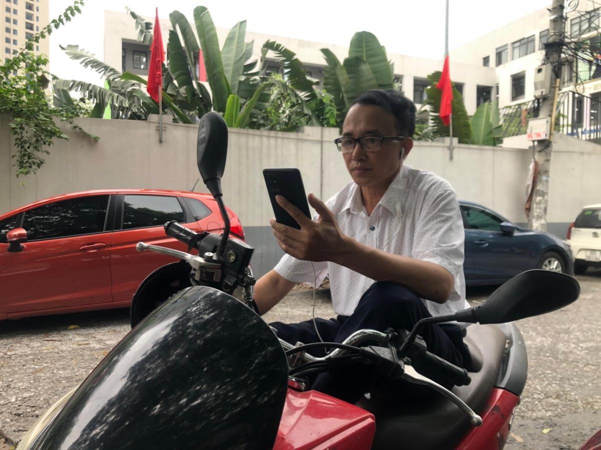  Nhiều phụ huynh tranh thủ nghe nhạc, xem YouTube trong lúc chờ đợi.