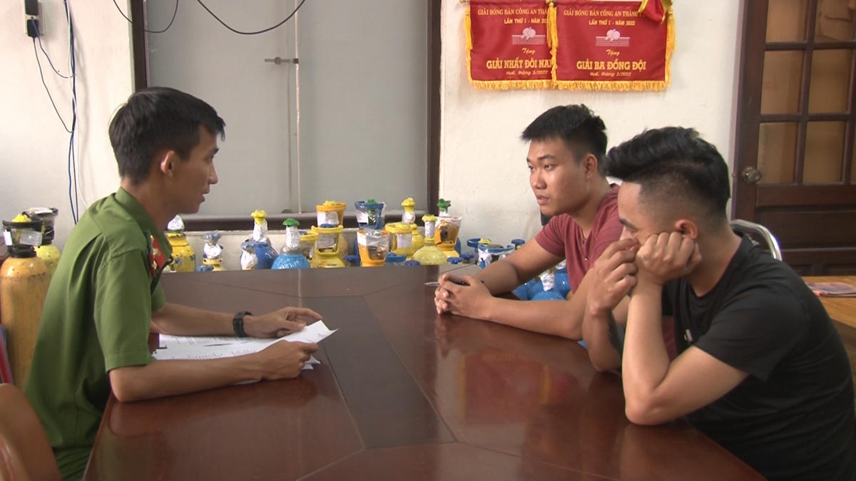 Công an làm việc với Lê Văn Quốc Minh (áo đỏ). Ảnh: Công Quang.