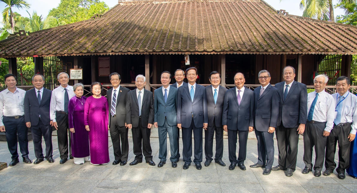 Chủ tịch nước Võ Văn Thưởng cùng các thành viên đoàn công tác Trung ương và tỉnh An Giang chụp hình lưu niệm tại nhà sàn thời niên thiếu Chủ tịch Tôn Đức Thắng.