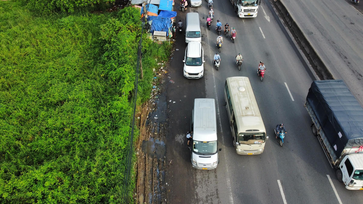 Những chiếc xe đưa đón công nhân nối đuôi nhau đón khách ngay nút giao Quốc lộ 51 – đường Đinh Quang Ân (phường Phước Tân). Ảnh: Mạnh Thìn. 