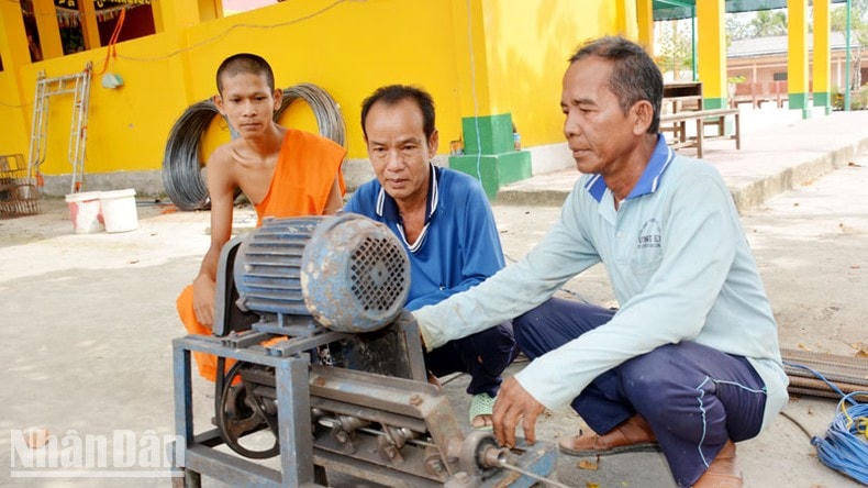 Ông Danh Hùng (bìa phải) cùng các thành viên trong đội thi công cắt sắt để xây cầu.