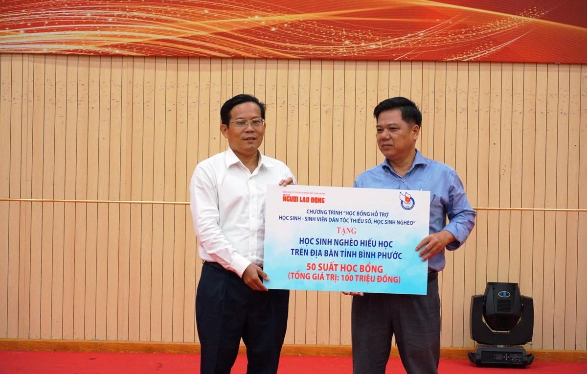 Tặng bảng tượng trưng trao học bổng cho học sinh nghèo hiểu học trên địa bàn tỉnh Bình Phước. Ảnh: Mạnh Thìn. 