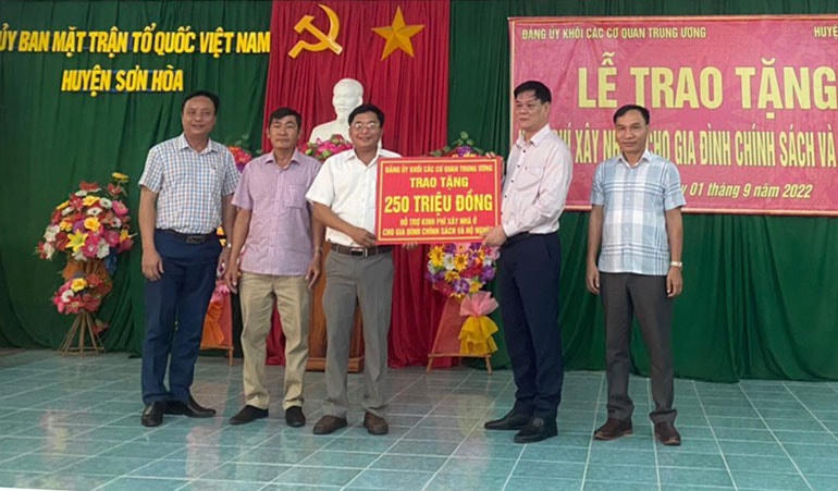 Ông Huỳnh Tấn Việt, Bí thư Đảng ủy Khối các cơ quan Trung ương trao bảng tượng trưng 250 triệu đồng, hỗ trợ UBND huyện Sơn Hòa, xây dựng 5 căn nhà cho gia đình chính sách và hộ nghèo.