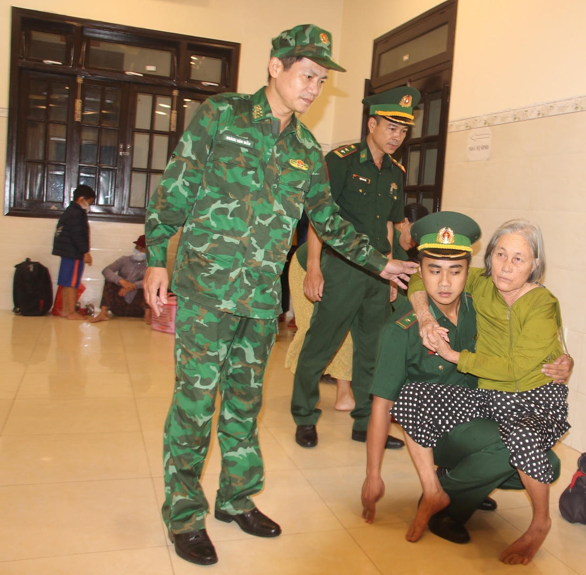 Lực lượng chức năng giúp người già yếu đưa đi tránh bão.