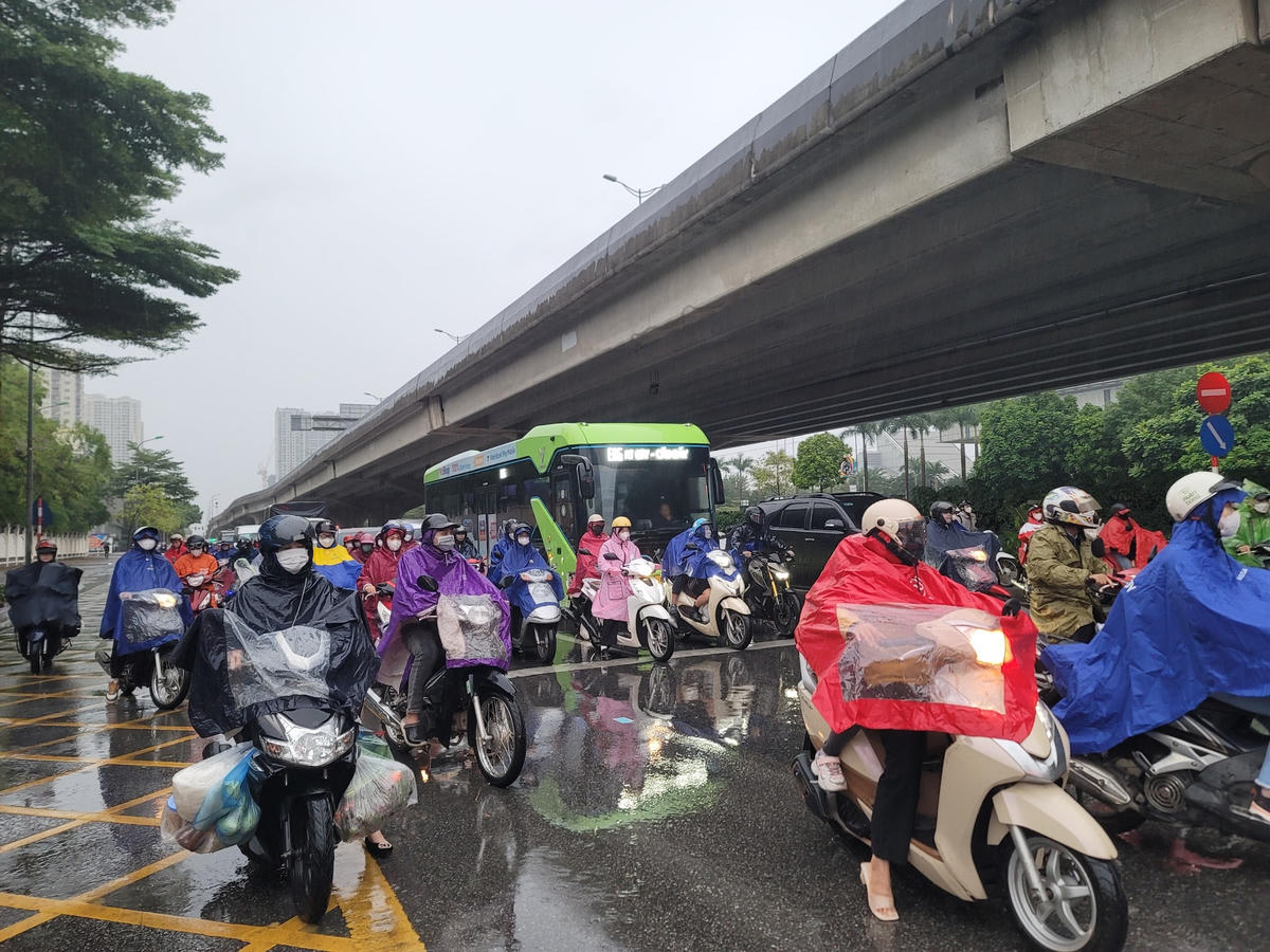 Không khí lạnh, kết hợp mưa khiến cho việc đi làm của người dân trở nên vất vả hơn.