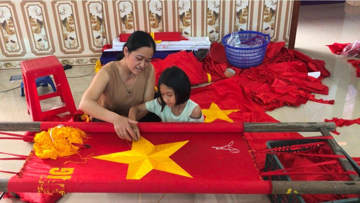 Người làng Từ Vân truyền cho con cháu nghề may cờ Tổ quốc. Ảnh: Phạm Thương
