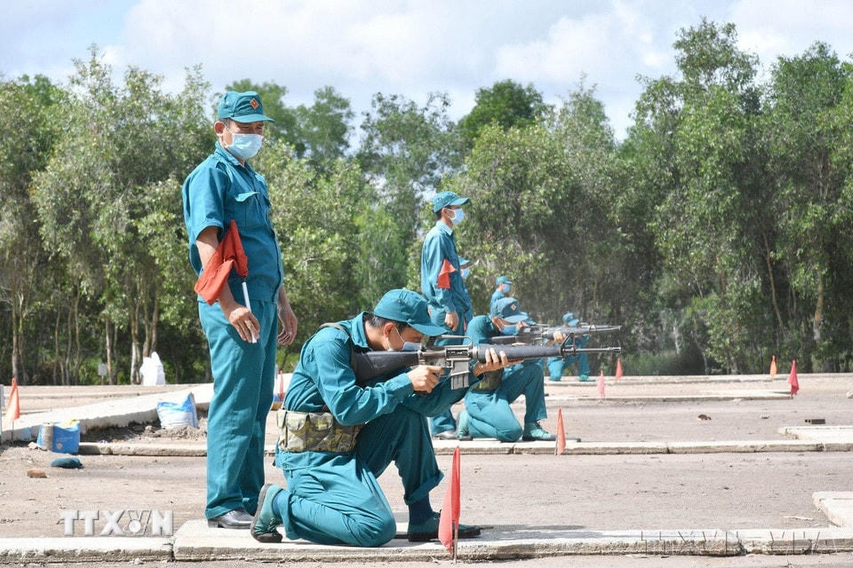 Các dân quân thường trực thực hiện thao tác ngắm bắn mục tiêu cố định bằng súng AK trong kỳ huấn luyện quân sự, tháng 6/2021. (Ảnh: Hữu Chí/TTXVN)